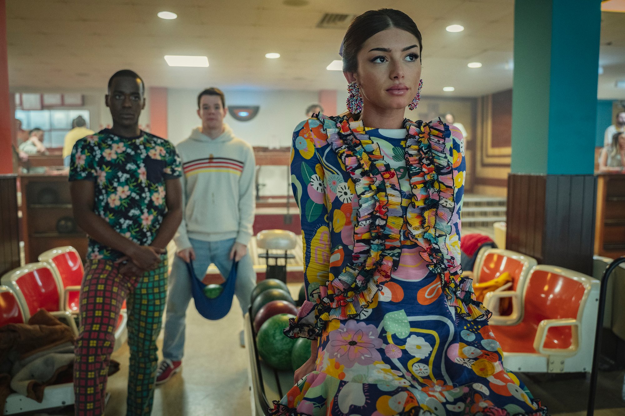Mimi Keene, Connor Swindells, and Ncuti Gatwa in a bowling alley in 'Sex Education' Season 3.