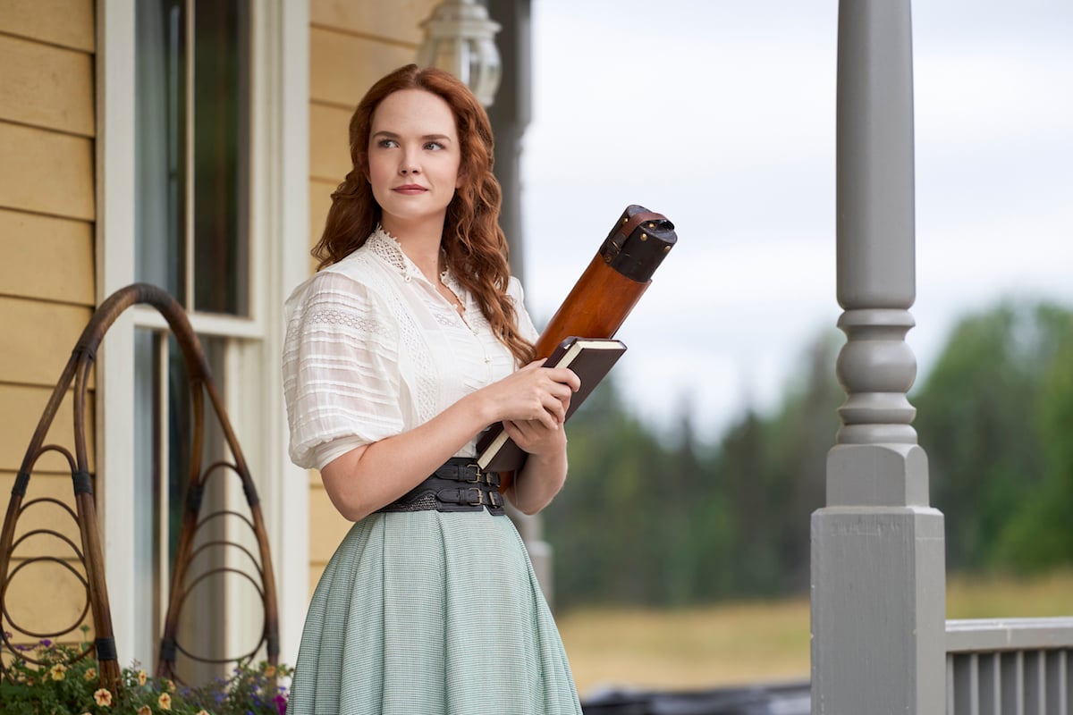 Morgan Kohan, standing on a porch and holding a book, in 'When Hope Calls'