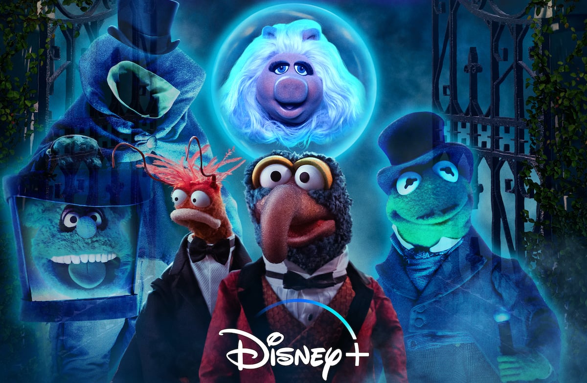 The Muppets in 'The Muppets Haunted Mansion' promotional image. Gonzo, Kermit the Frog, Miss Piggy, Fozzie Bear, and Pepé the King Prawn appear as various characters from Disney's 'The Haunted Mansion' ride and stand in front of an open iron gate surrounded by fog. 'Muppets Haunted Mansion' debuts on Disney+ on Oct. 8 as part of Disney+'s Hallostream collection.