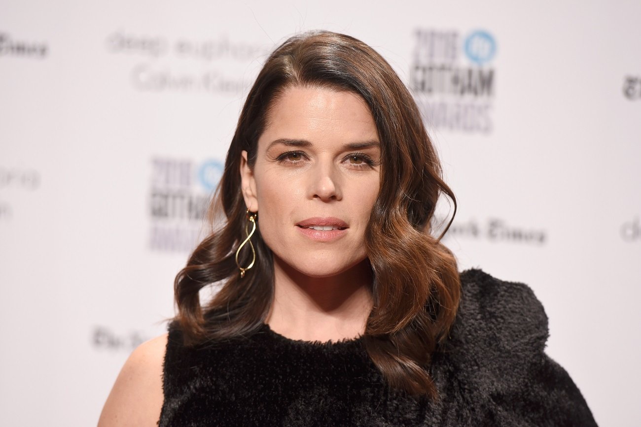 Scream 5 star Neve Campbell wears a black dress.