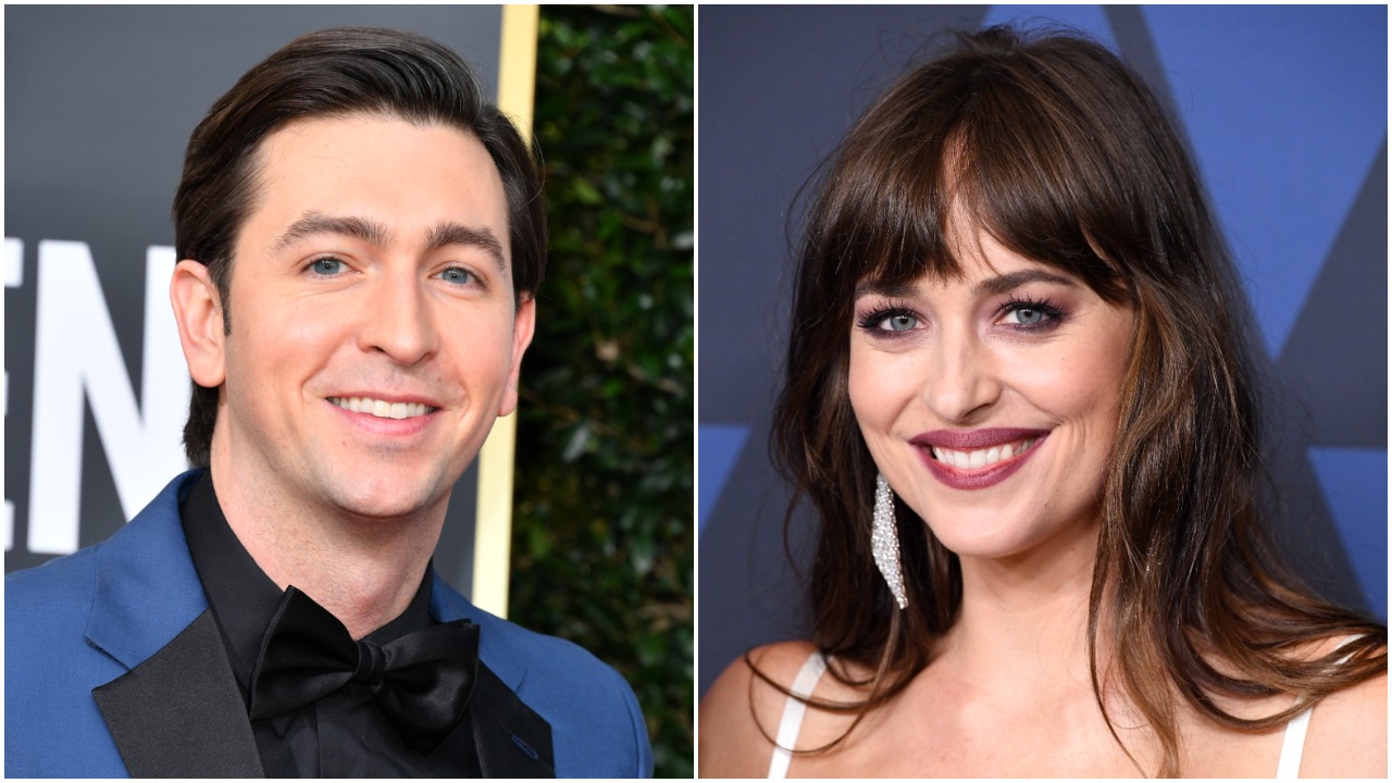 Nicholas Braun in a blue suit and Dakota Johnson in a white dress.