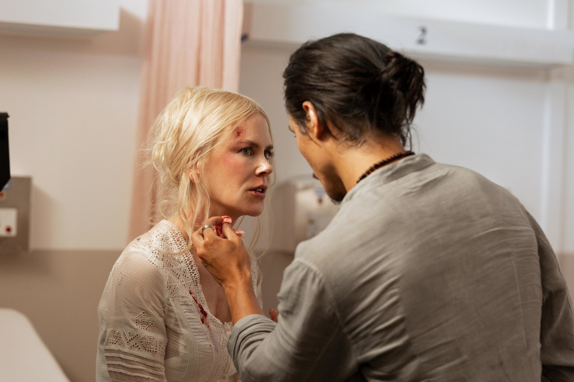 A shot of 'Nine Perfect Strangers' Episode 7 sees Yao (Manny Jacinto) looking at a cut on Masha's (Nicole Kidman) head. He's holding his hand up to her face, and she's tilting her head with her hair back.