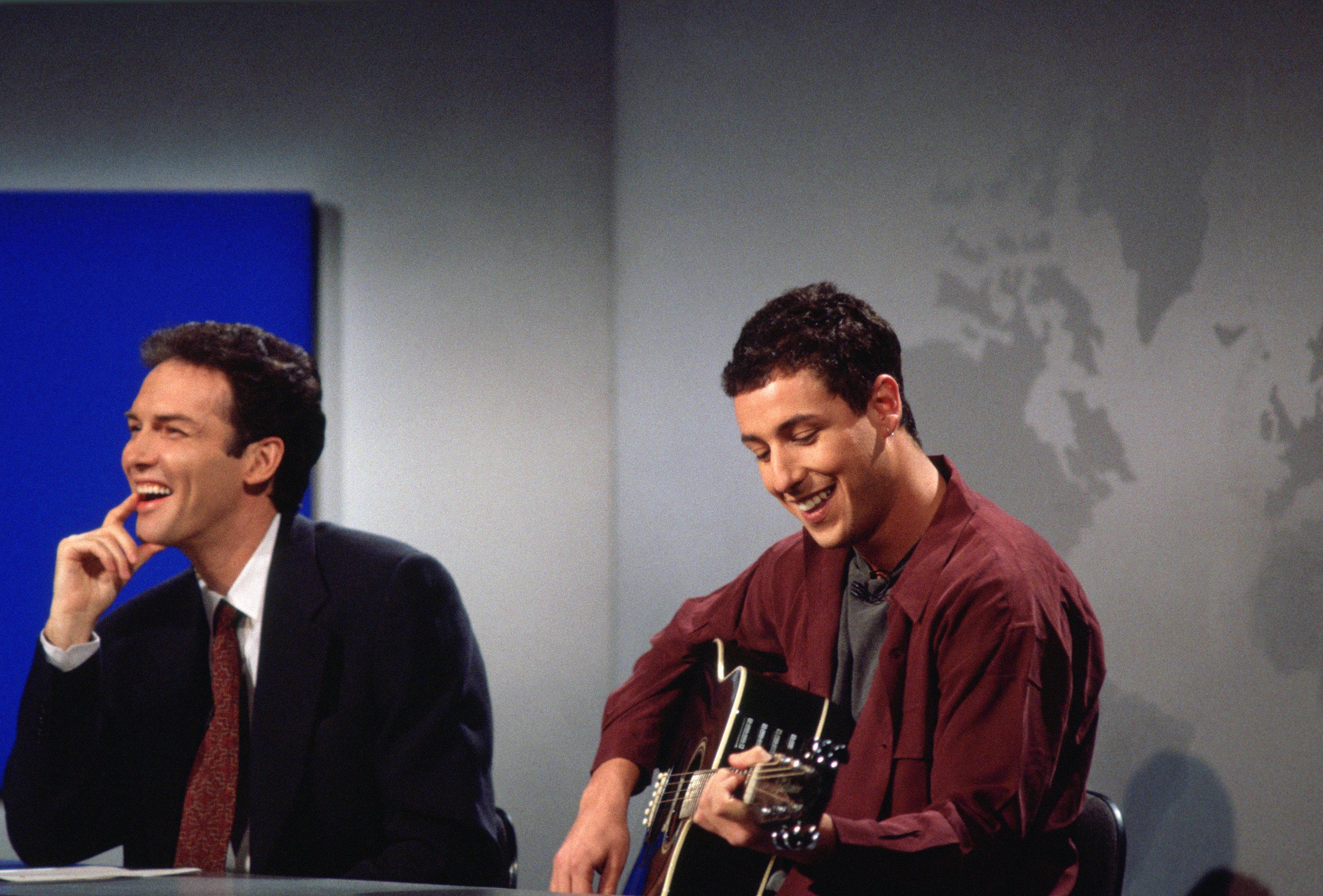 Norm Macdonald laughs while Adam Sandler plays guitar