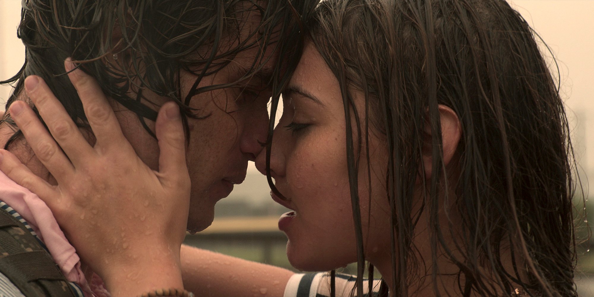 Chase Stokes and Madelyn Cline kissing in the rain in ‘Outer Banks’ Season 1.