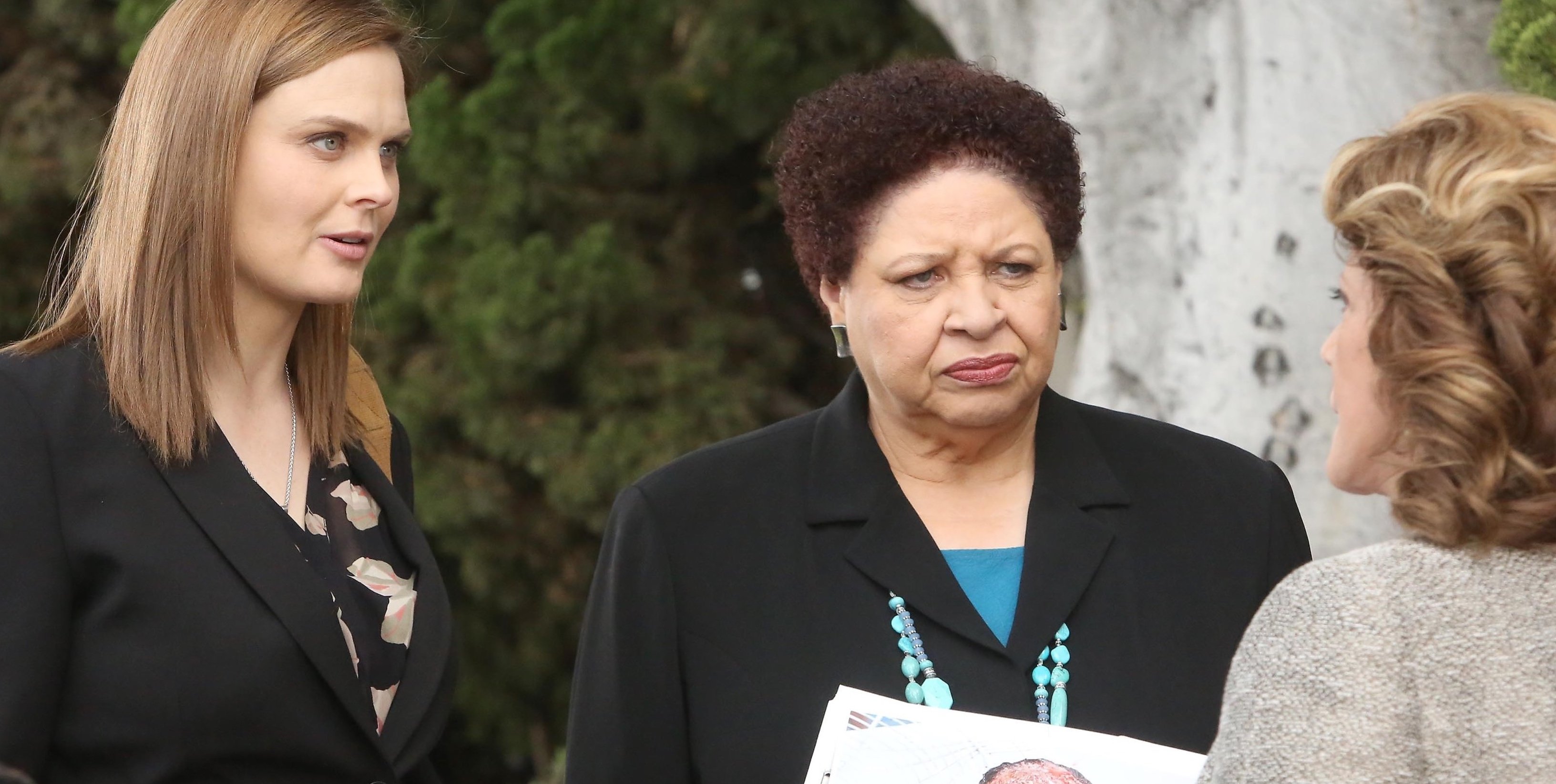 Patricia Belcher as Caroline 'Bones' wearing blue shirt and black blazer