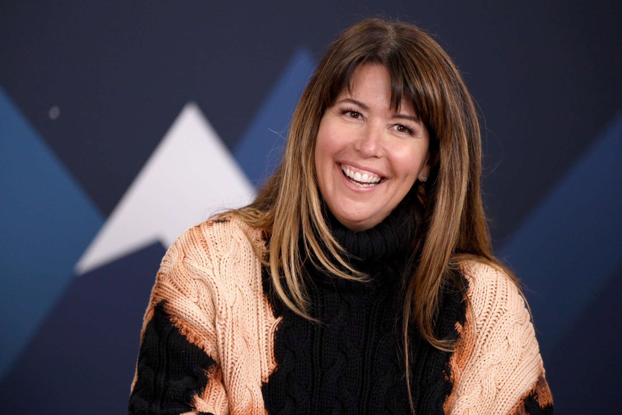 'Wonder Woman: 1984' director Patty Jenkins. Her brown hair is straight and down. She's wearing a black sleeveless shirt and smiling.