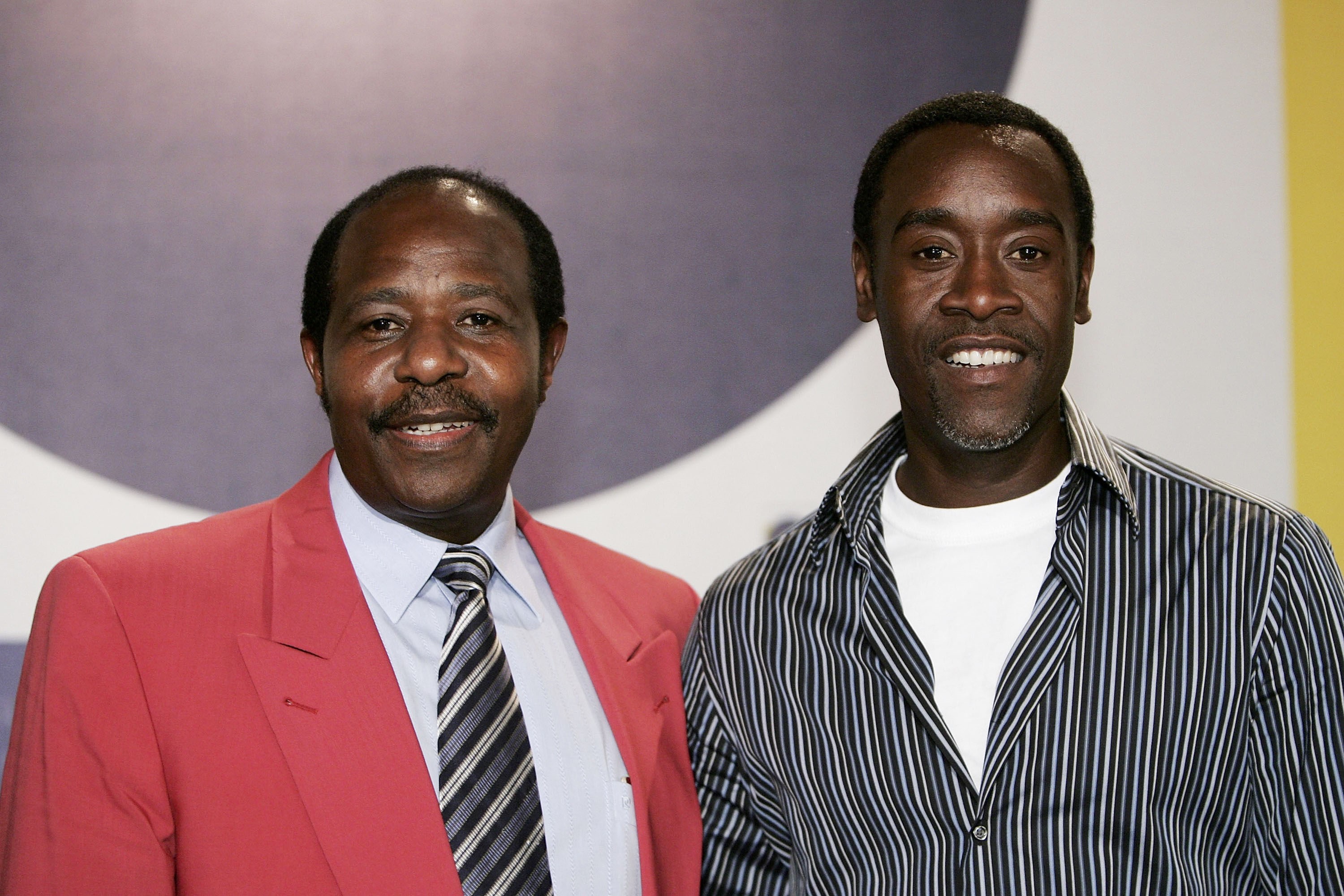Paul Rusesabagina, in a pink suit with a white shirt and tie, and Don Cheadle in a blue shirt, attend the Berlin International Film Festival for their movie 'Hotel Rwanda.'