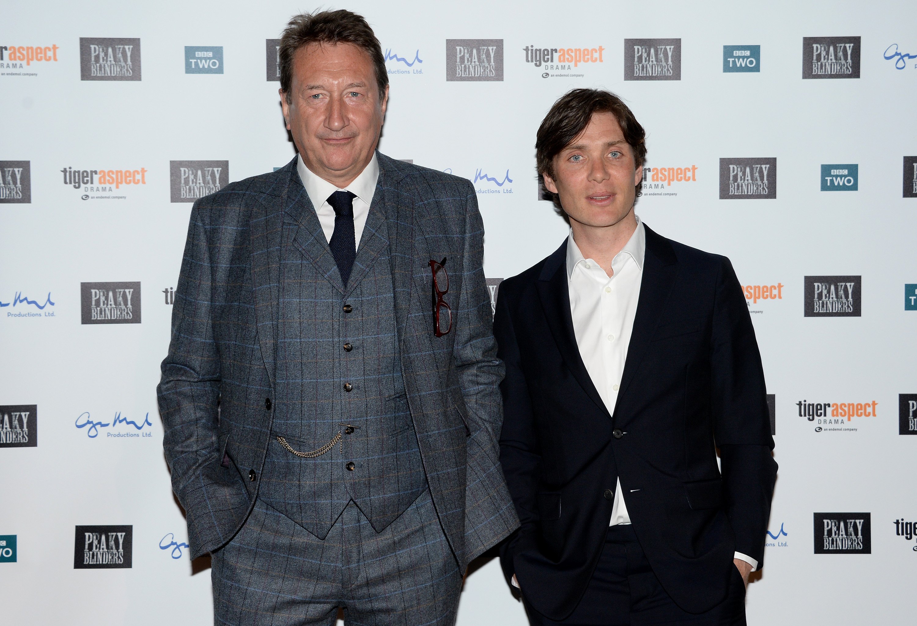 Steven Knight and Cillian Murphy at the premiere of 'Peaky Blinders' Season 3, Episode 1. Knight is wearing a suit and tie and Murphy is wearing a white dress shirt and black jacket.