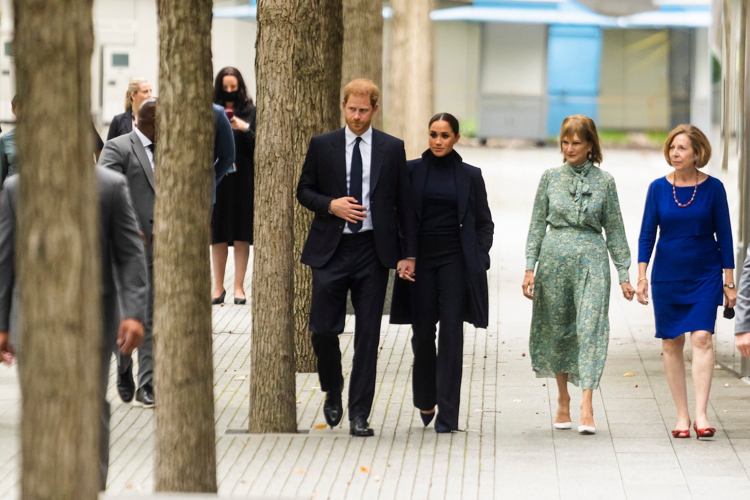 Prince Harry and Meghan Markle hold hands as they walk along a waterfall at the World Trade Center