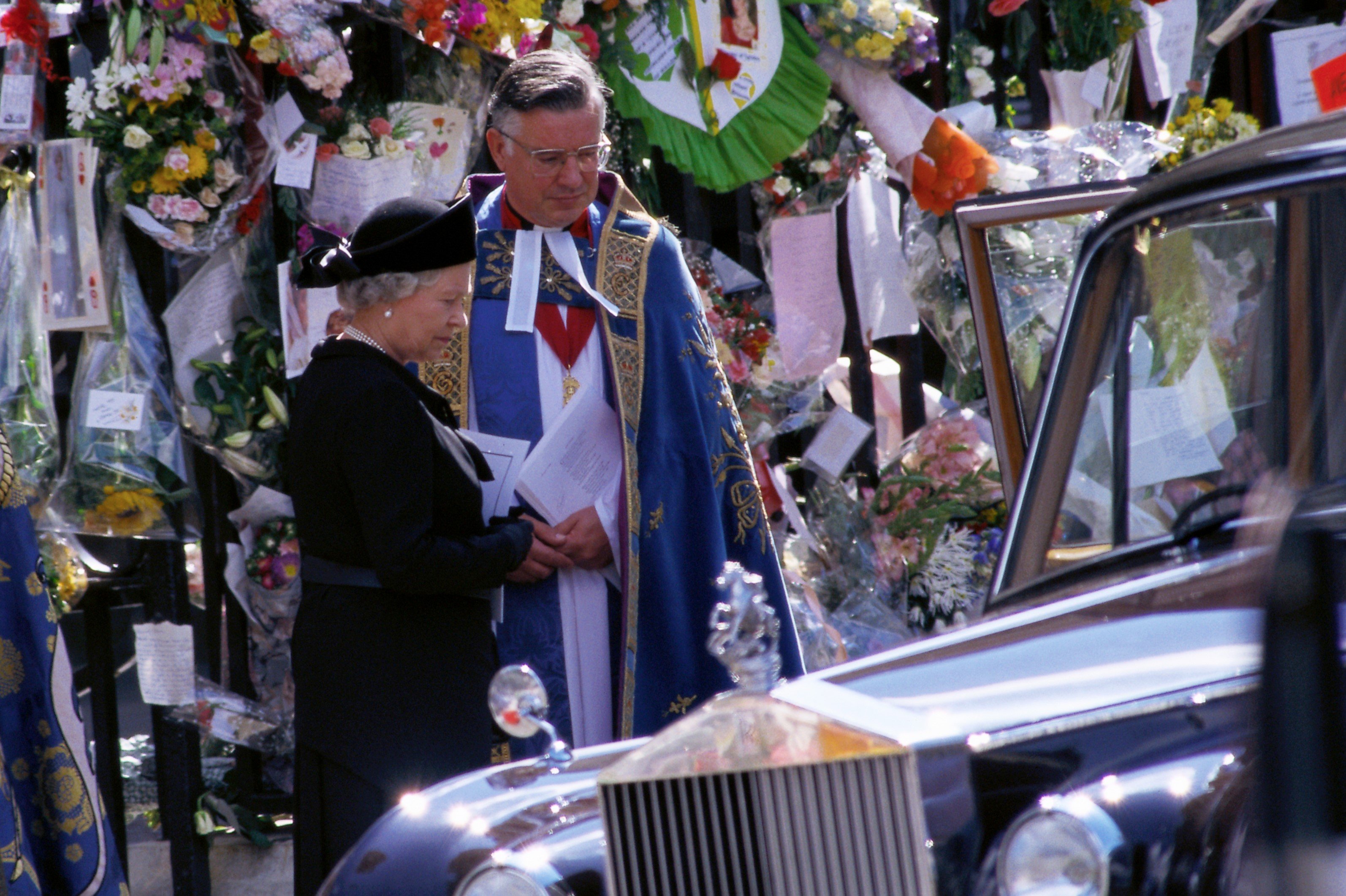 Queen Elizabeth stands with a priest at the funeral of Princess Diana