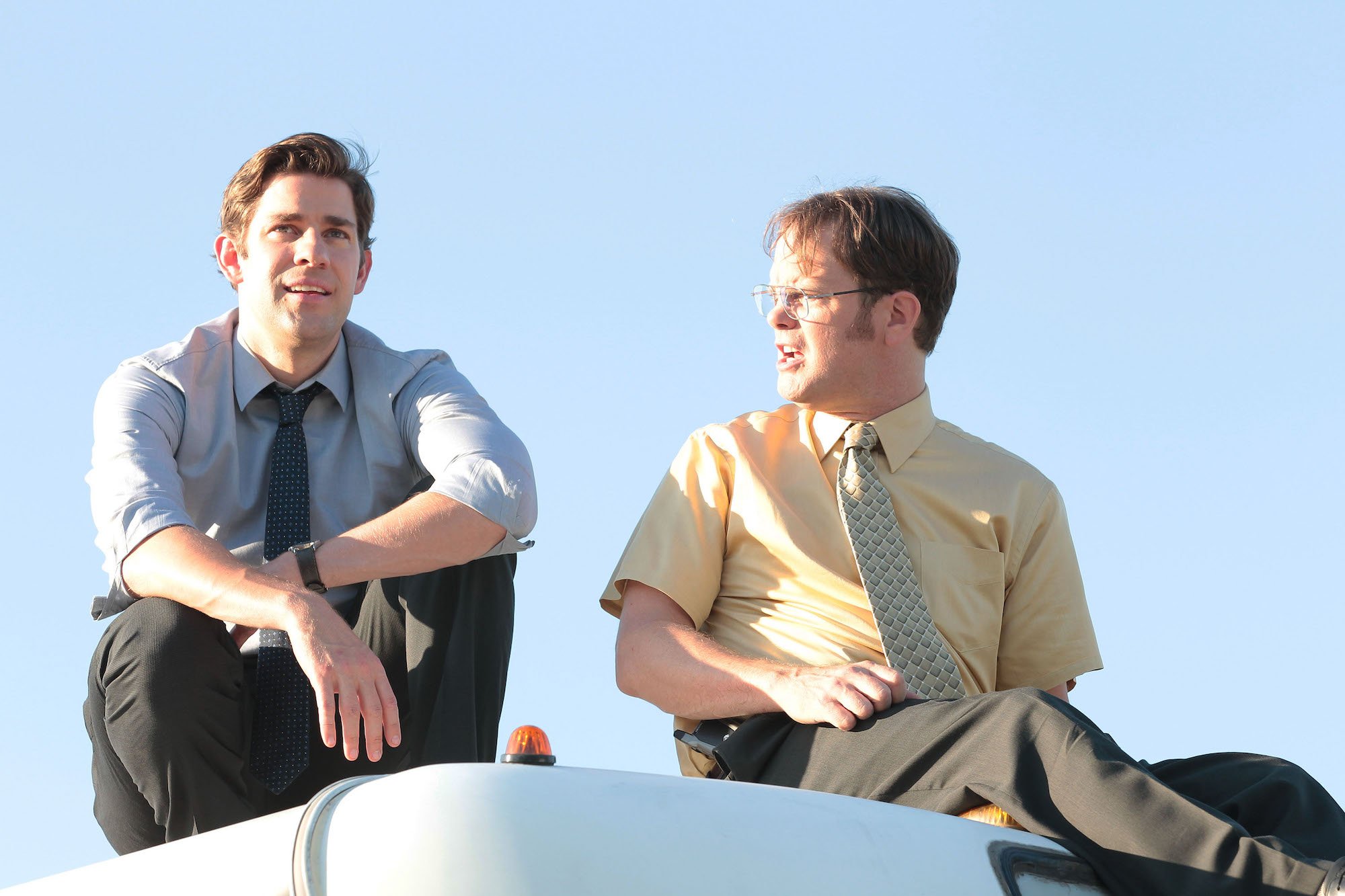 Rainn Wilson, and John Krasinski having a conversation in 'The Office' Season 9