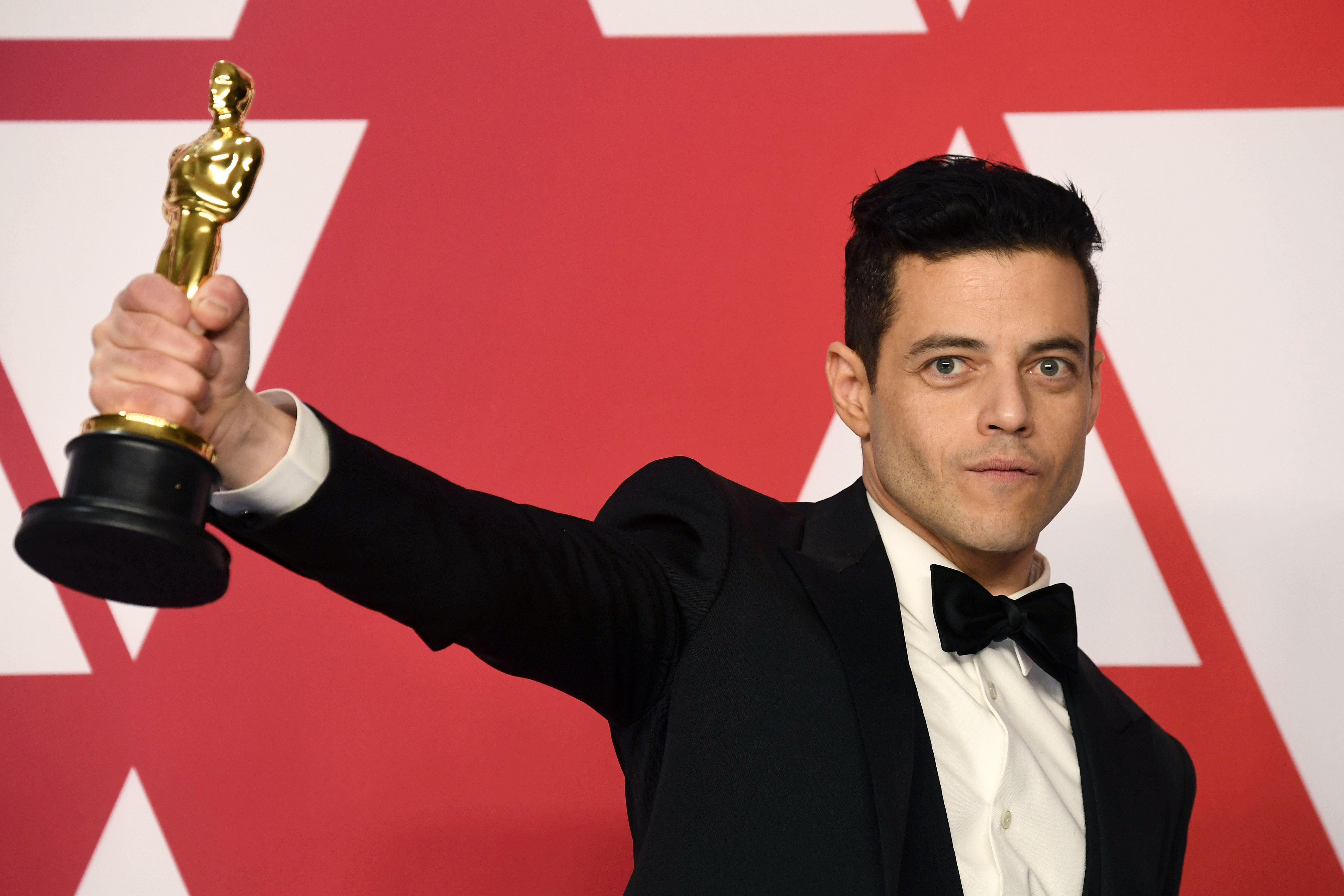 Rami Malek, star of No Time to Die, holds up his Oscar award