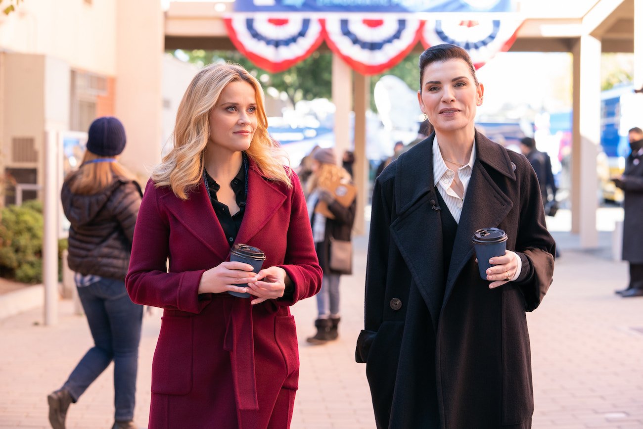 Reese Witherspoon and Julianna Margulies walk next to each other holding coffee cups in a scene from 'The Morning Show' Season 2