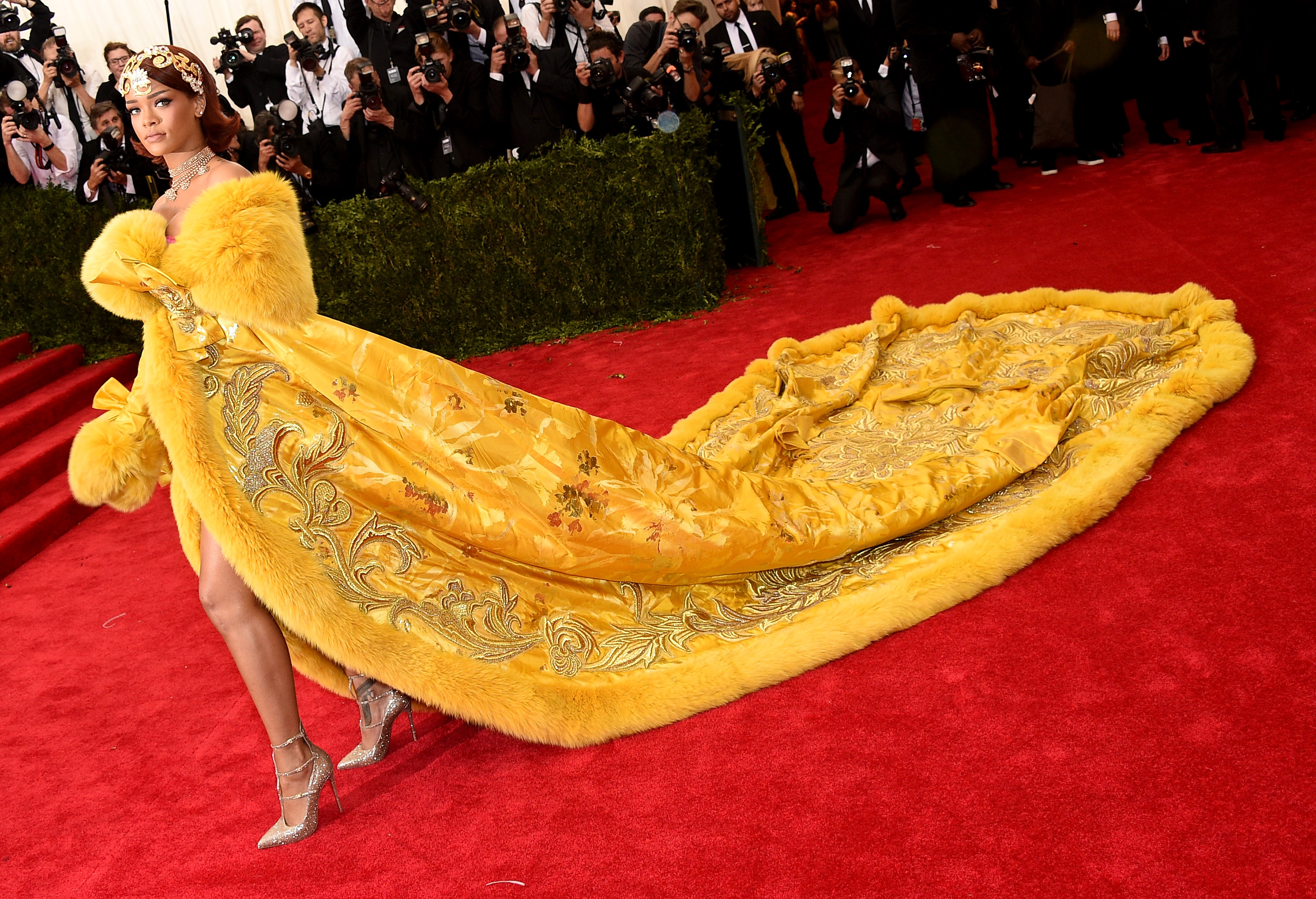 Rihanna posing in a yellow gown at the 2019 Met Gala.