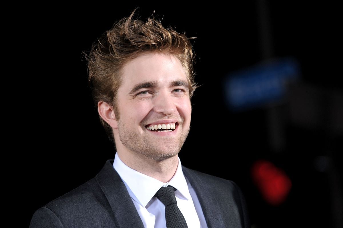 Robert Pattinson smiles at a movie premiere