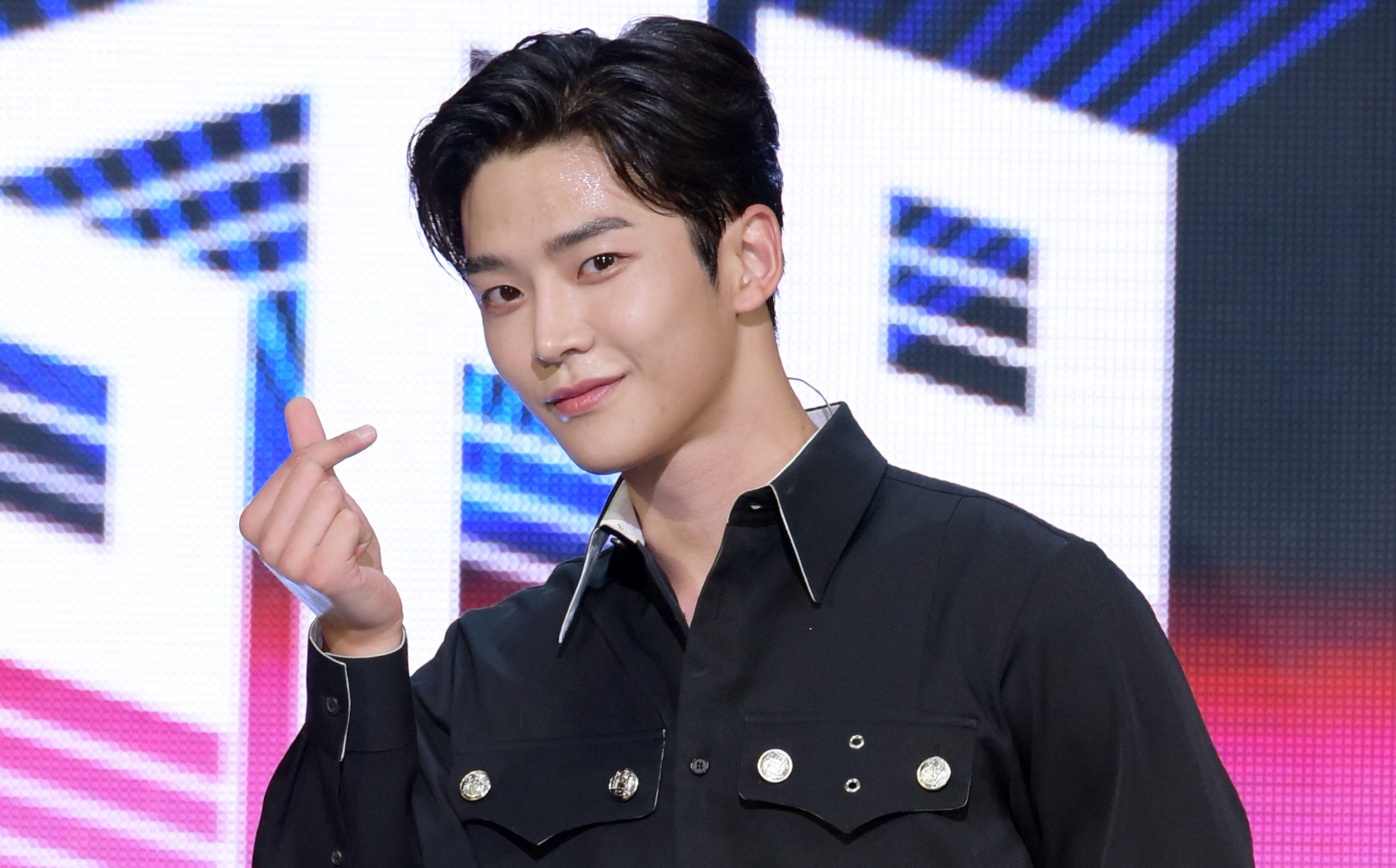 Rowoon 'The King's Affection' wearing black button up and doing heart fingers
