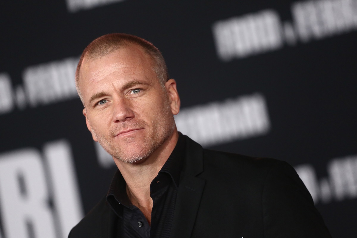 Actor Sean Carrigan wears a black suit at the premiere of the 2019 film 'Ford v Ferrari.'