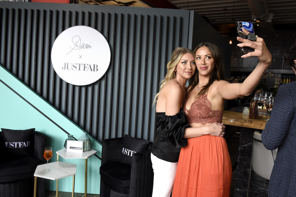Stassi Schroeder and Kristen Doute hug while taking a selfie at an event.