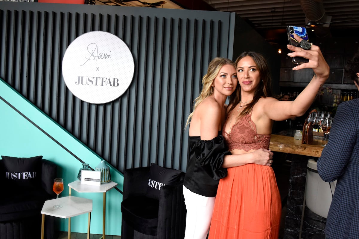 Stassi Schroeder and Kristen Doute hug while taking a selfie at an event.