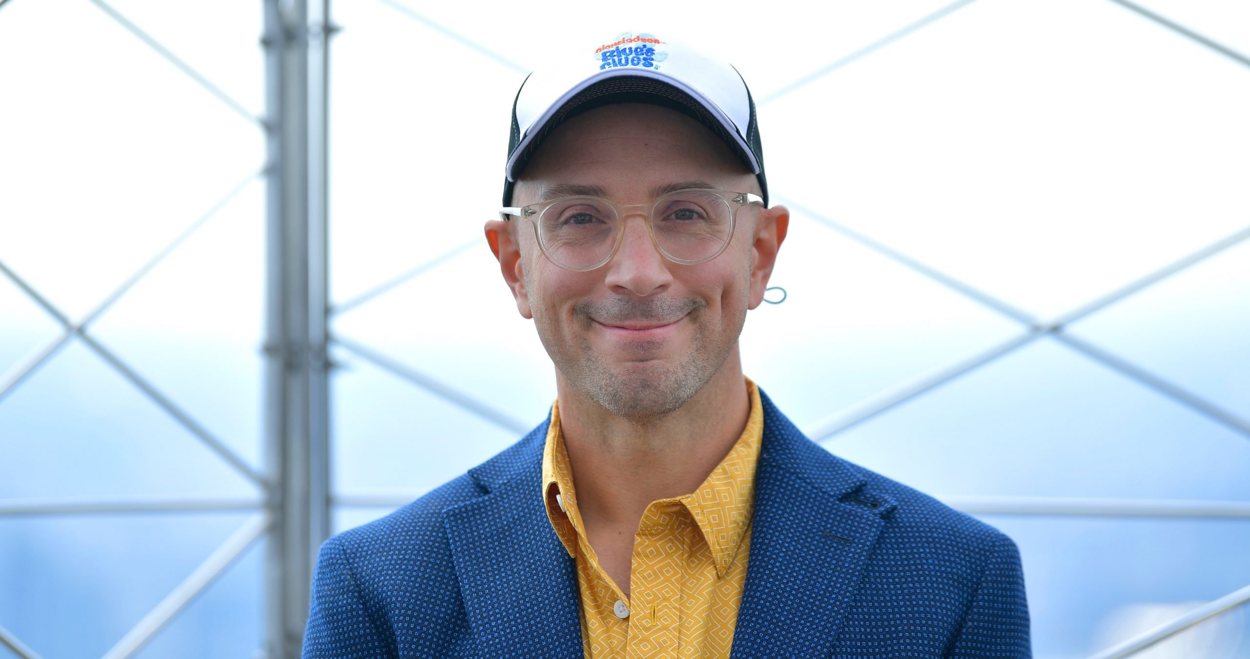 ‘Blue’s Clues’ host Steve Burns at 25th Anniversary celebration in a blue suit jacket and yellow button up.