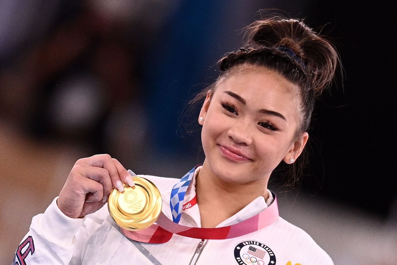 Suni Lee holding a gold medal at the Olympics
