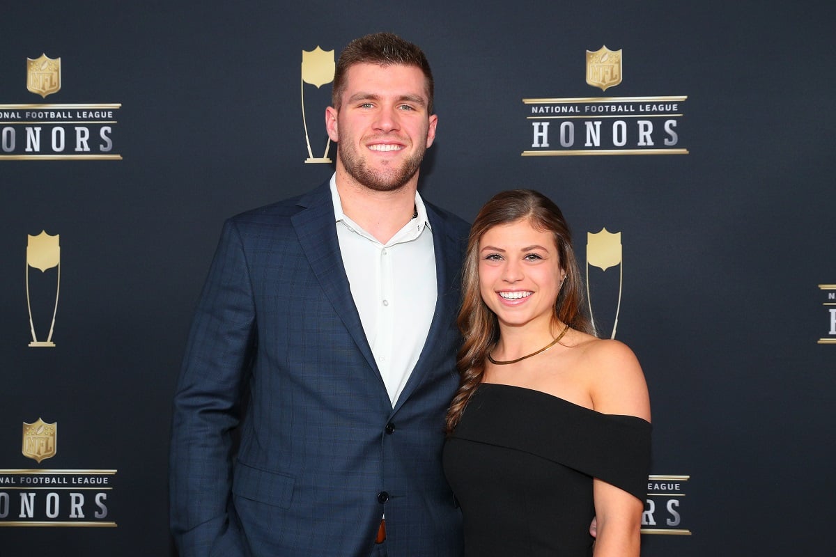 T.J. Watt and Dani Rhodes smile for photographs on the red carpet at NFL Honors