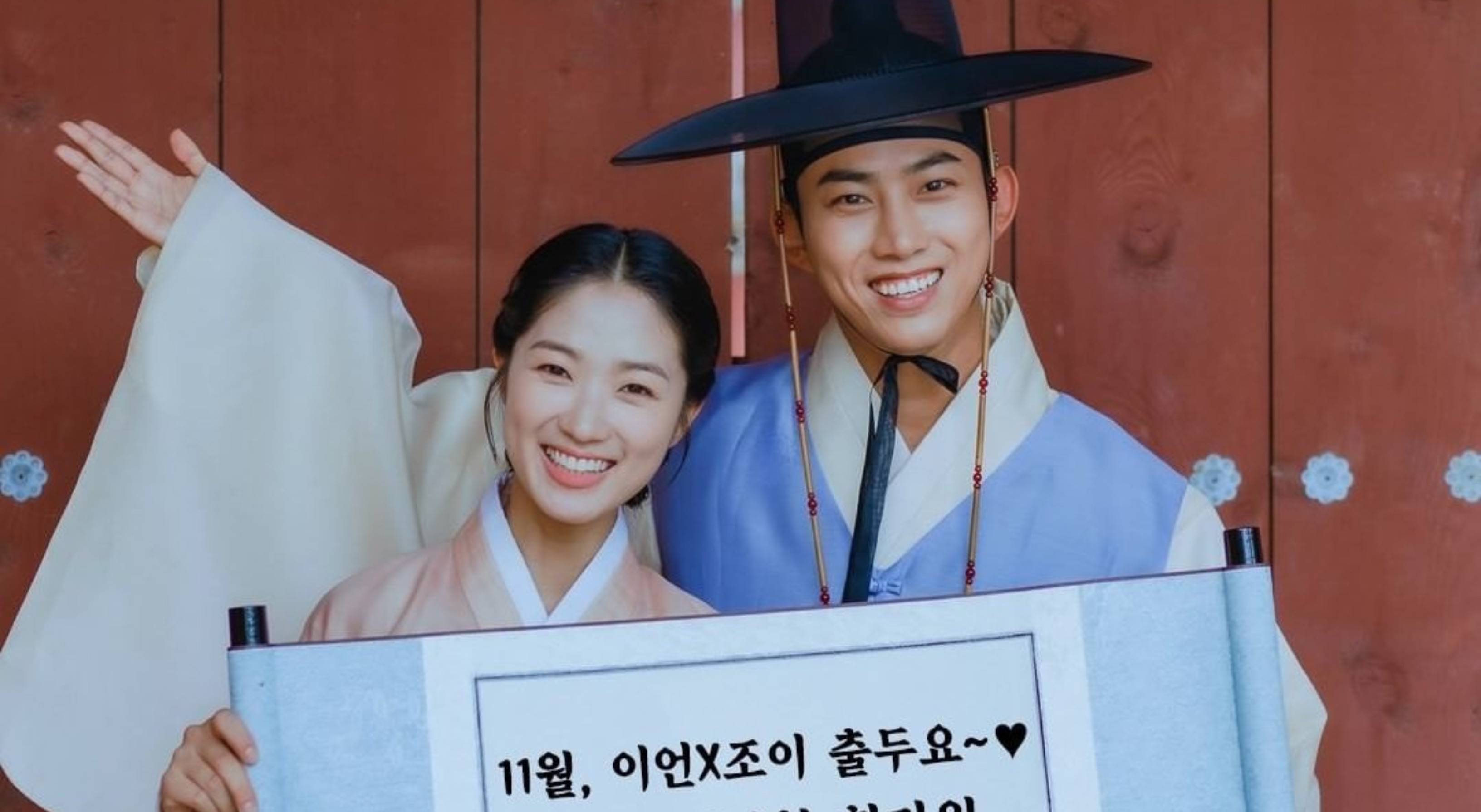 Taecyeon and Kim Hey-Yoon in 'Inspector Joy' K-drama wearing hanboks holding banner