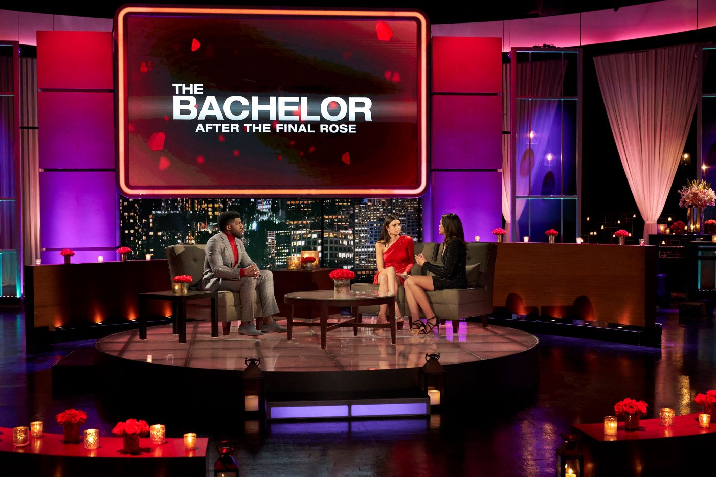 Contestants from 'The Bachelor' on a large stage with during an interview.