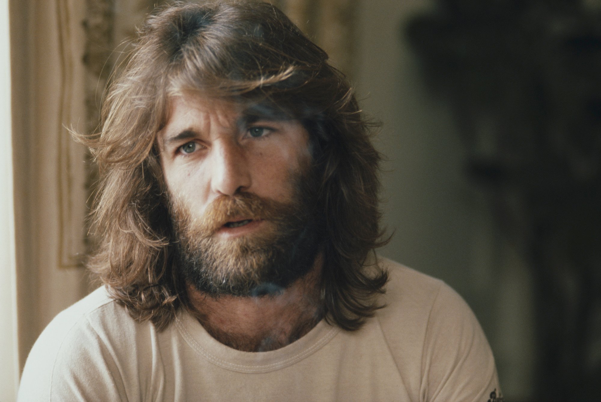Dennis Wilson talking, sitting in front of a blurred background
