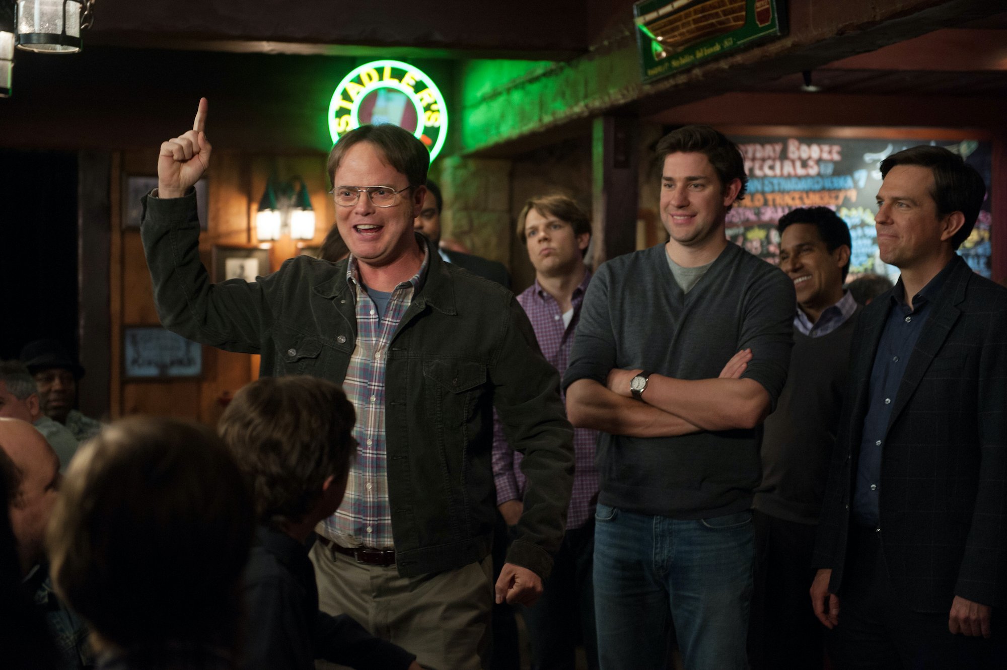 Cast members of 'The Office' in a bar, smiling and laughing
