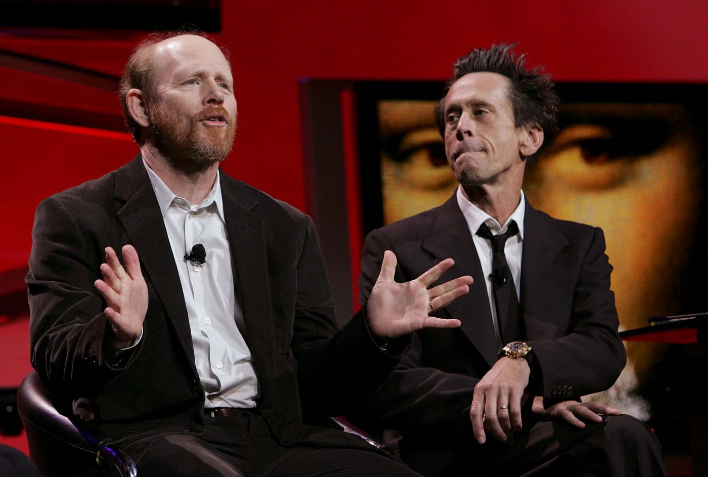 Director Ron Howard and producer Brian Grazer from 'The Davinci Code' wearing suits against a red background.