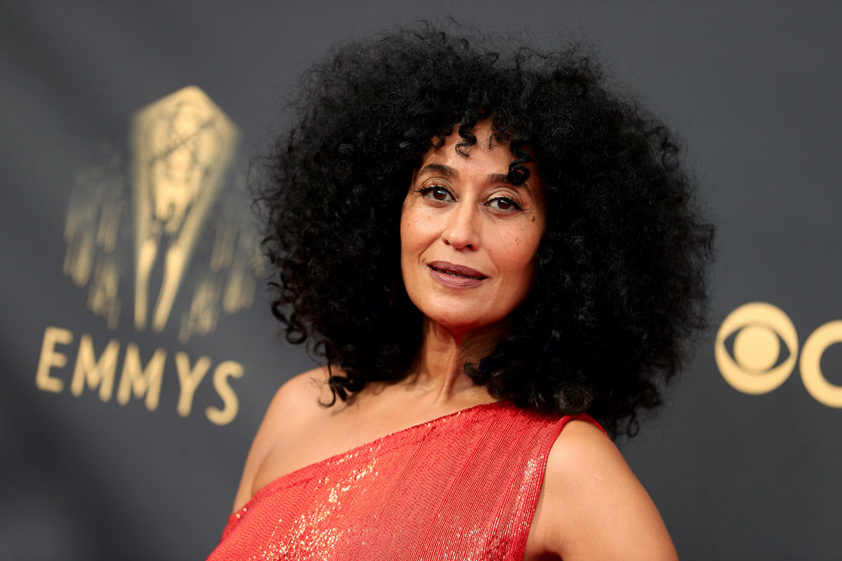 Tracee Ellis Ross smiling in front of a black and gold background