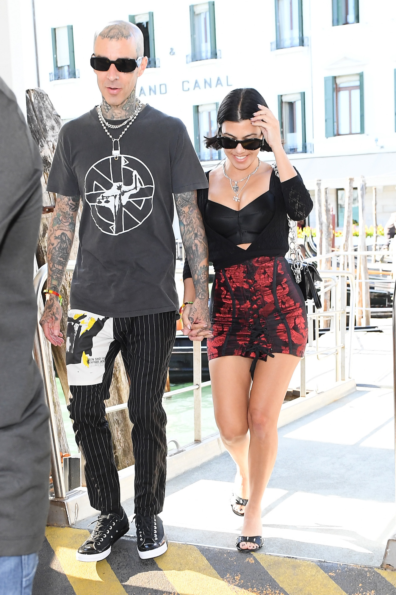 Travis Barker and Kourtney Kardashian holding hands while walking around Venice, Italy