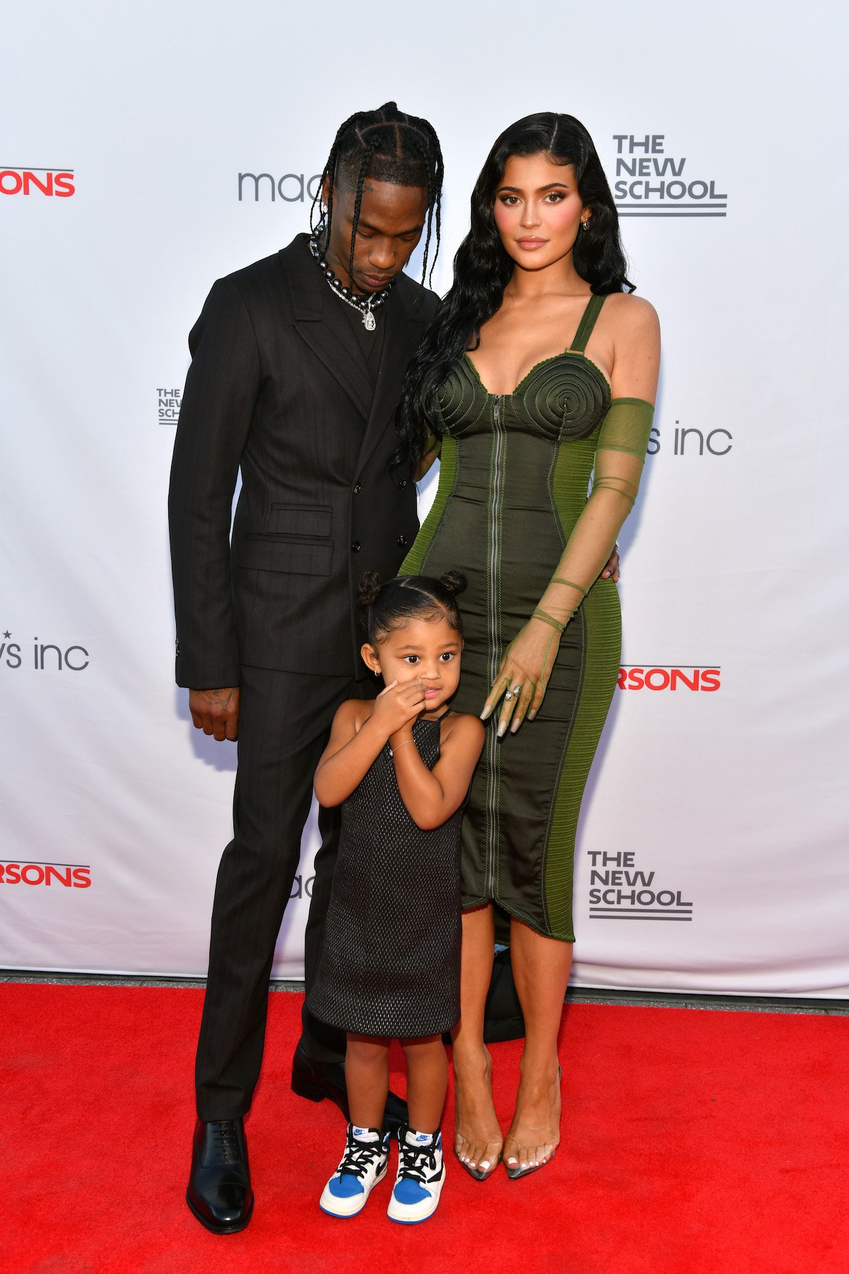 Travis Scott, Kylie Jenner, and their daughter Stormi Webster pose together at an event.