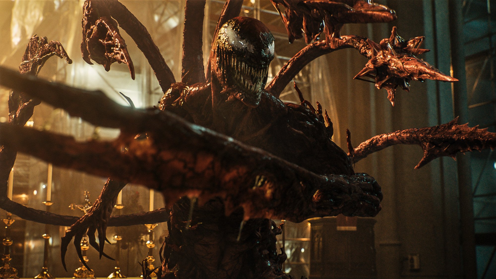 Carnage in Sony Pictures' 'Venom: Let There Be Carnage,' which has a PG-13 rating. His teeth are bared and his spiked limbs are pointing at someone off-screen.