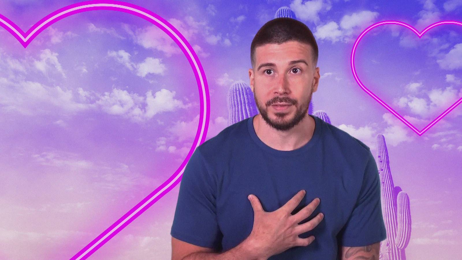 Vinny Guadaganino in front of a green screen with neon hearts on the set of 'Double Shot at Love' Season 3