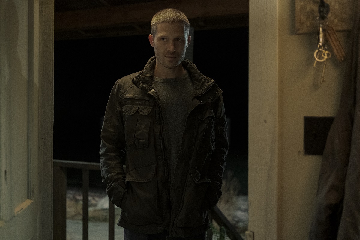 Zach Gilford stands in an open doorway in 'Midnight Mass.'