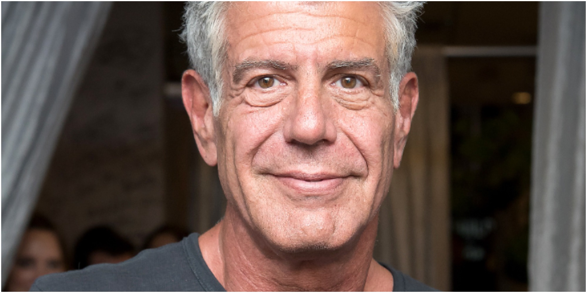 Anthony Bourdain poses in a t-shirt.