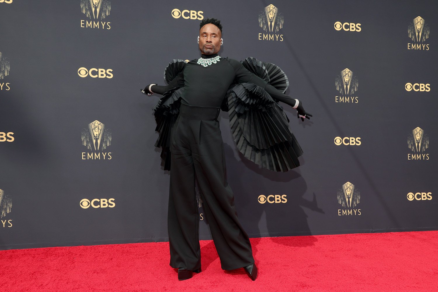 Billy Porter wears a black outfit with wing ruffles and diamonds on the 2021 Emmys red carpet