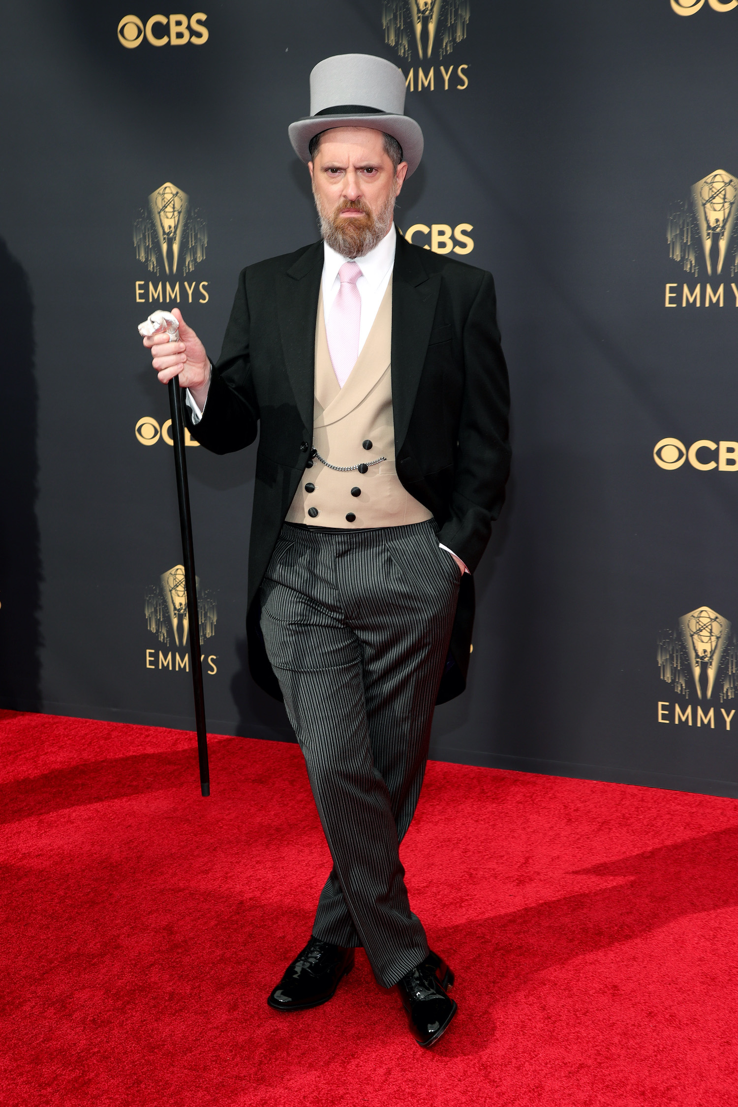 Brendan Hunt wears a tuxedo with tails, top hat, and cane on the red carpet at the 2021 Emmys 