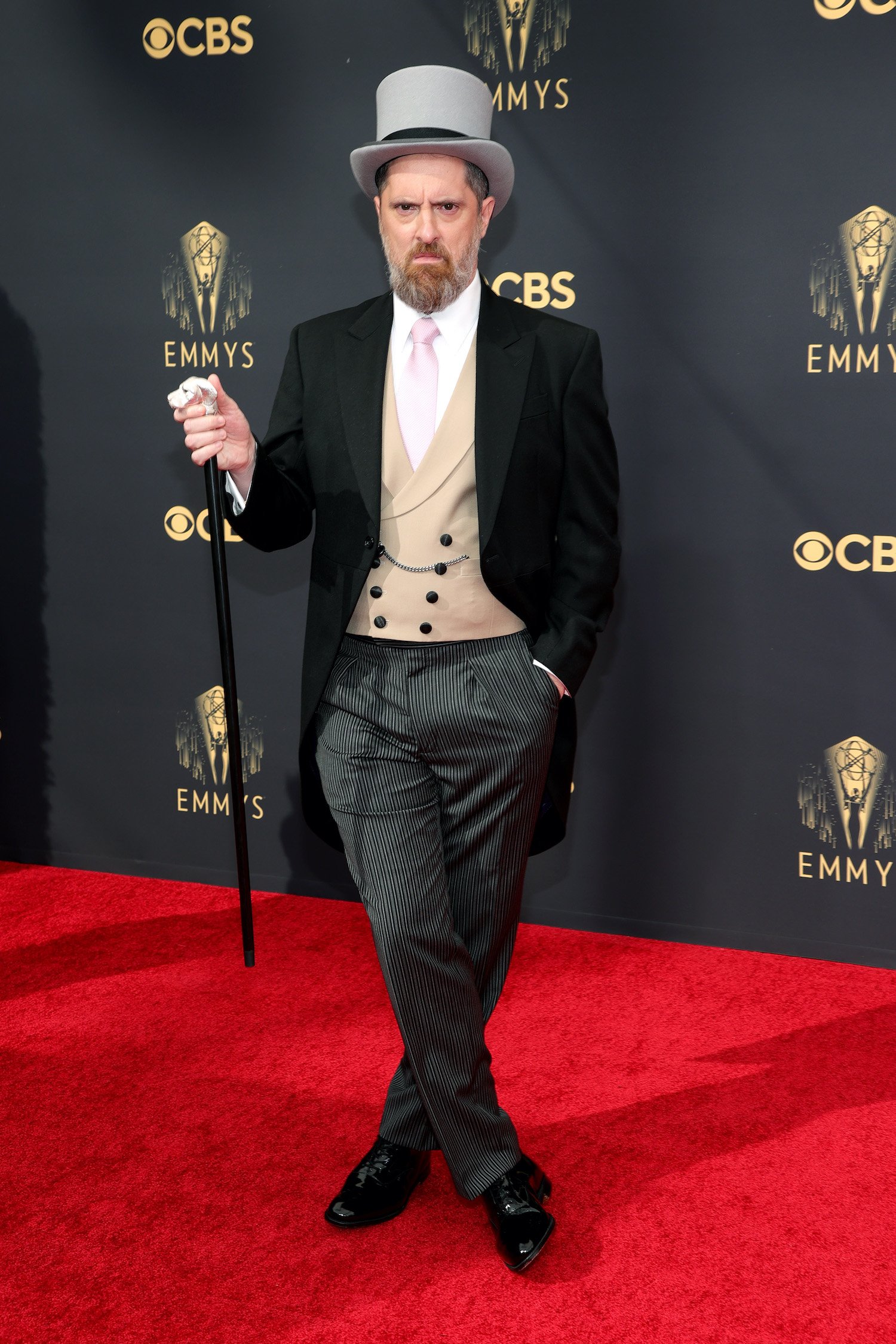 Brendan Hunt wears a tuxedo with tails, top hat, and cane on the red carpet at the 2021 Emmys