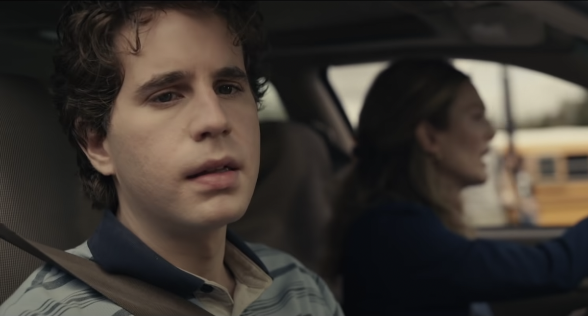Ben Platt is seen in the 'Dear Evan Hansen' movie trailer. He sits in a car looking out the window with a concerned look on his face and wearing the character's signature blue striped polo shirt. Julianne Moore is in the driver's seat playing his mother, Heidi. 