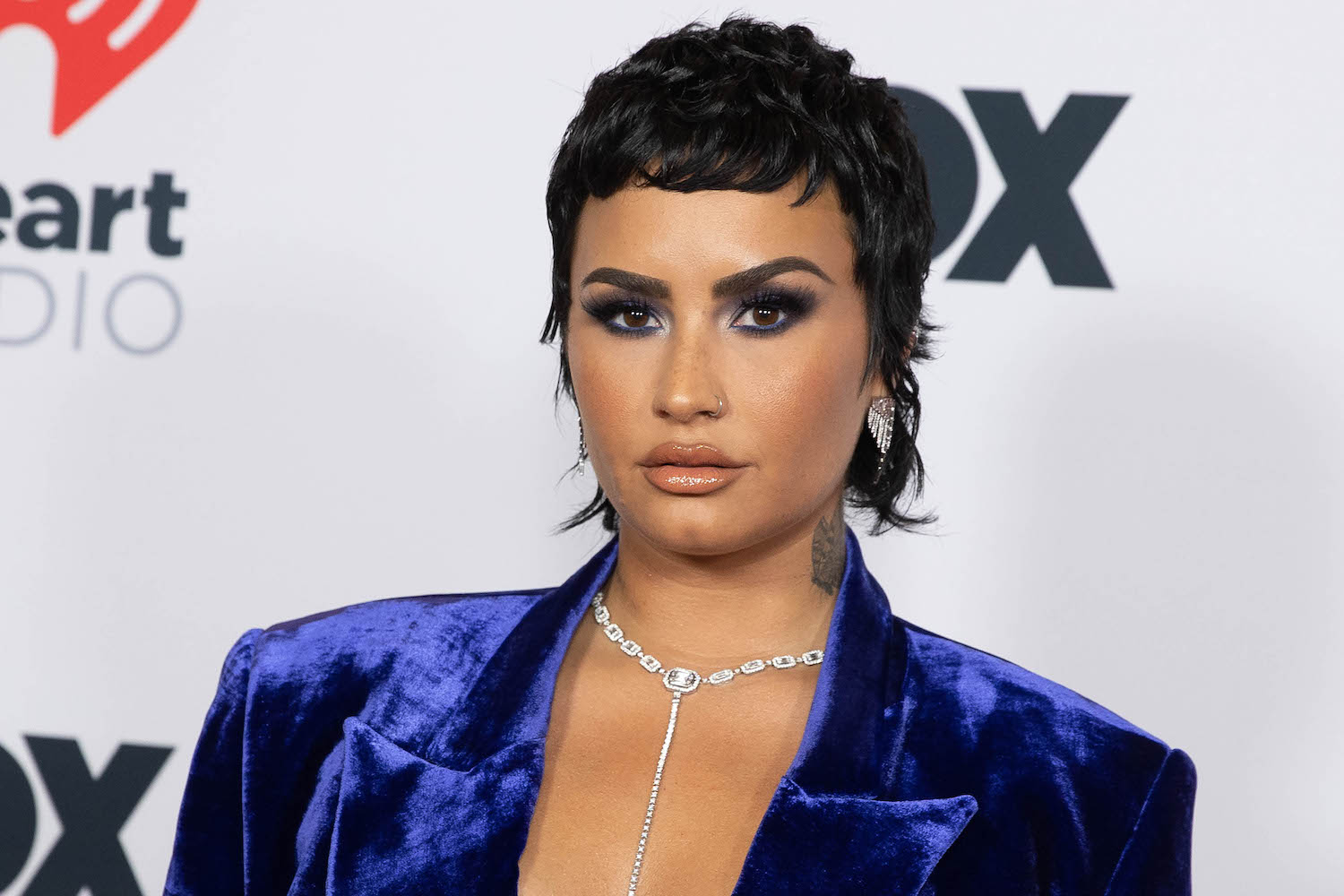 Demi Lovato arrives at the 2021 iHeartRadio Music Awards wearing a vibrant blue jacket