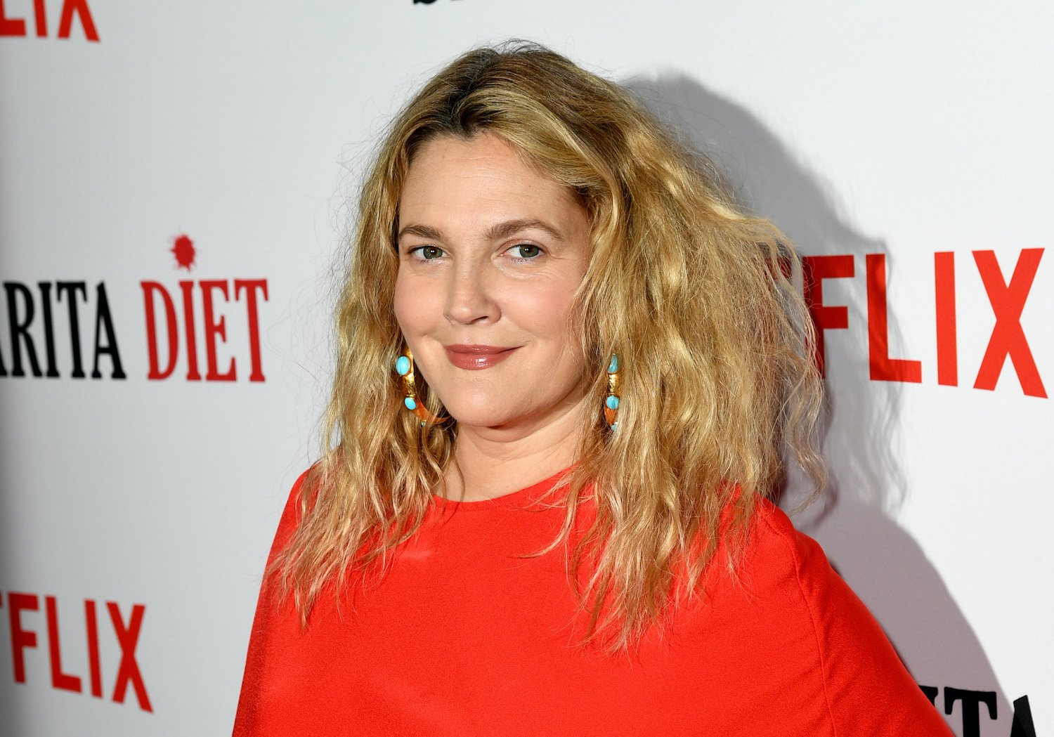 Drew Barrymore wears a red dress and smiles at the premiere of Netflix's 'Santa Clarita Diet' season 2