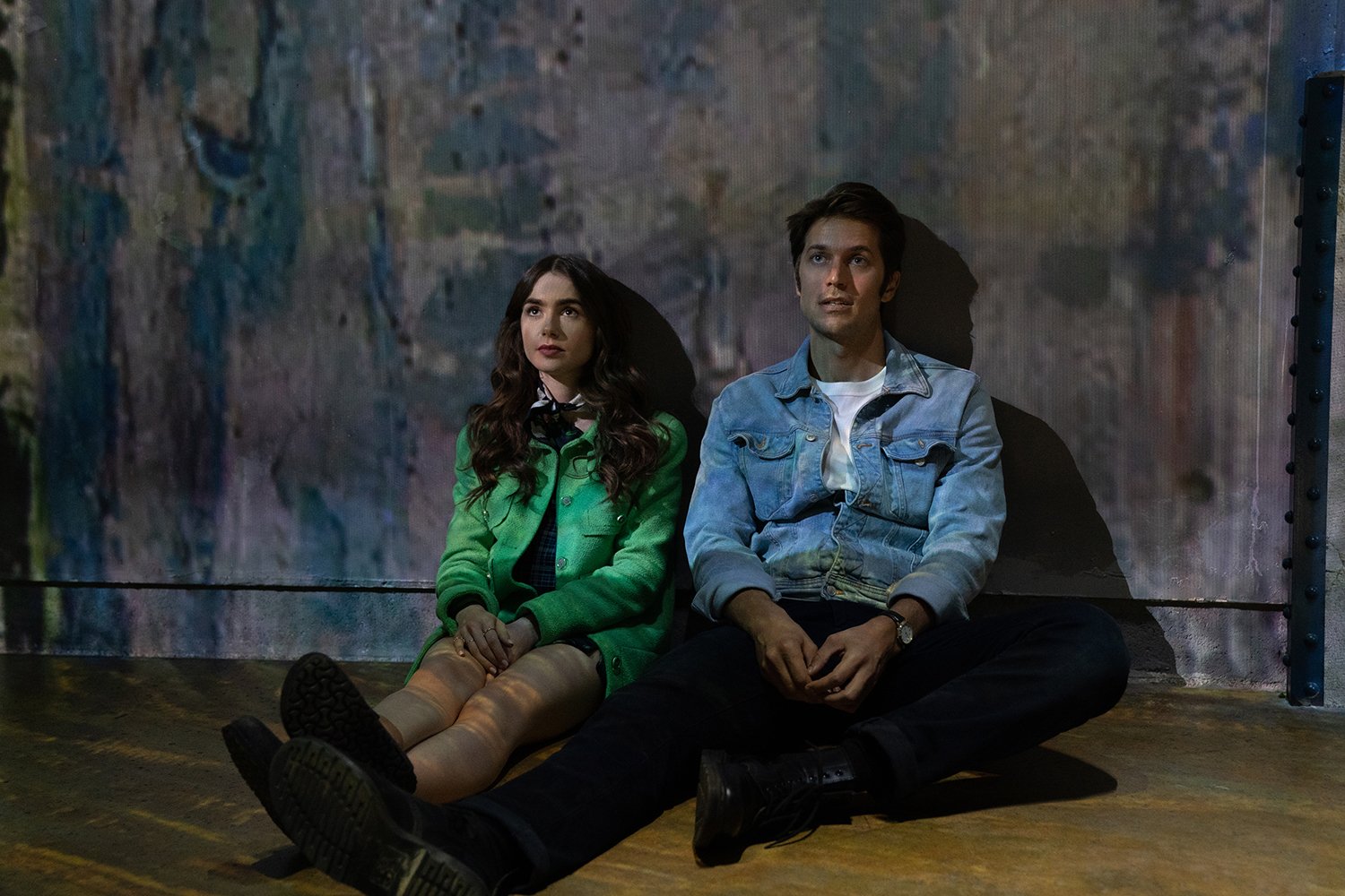 Emily in Paris stars Lily Collins and Lucas Bravo lean against a wall in season 1
