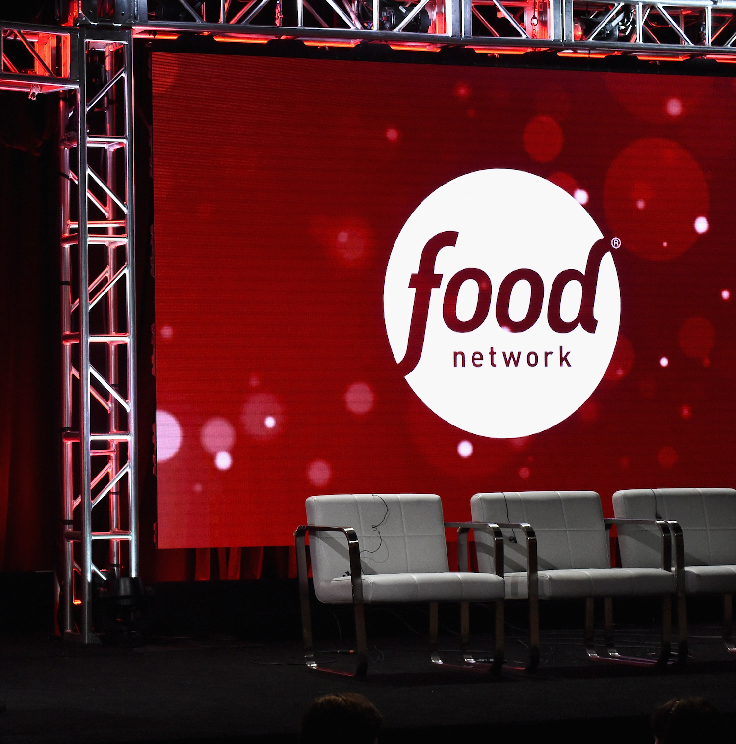 Food Network logo projected on a screen with three gray chairs in front