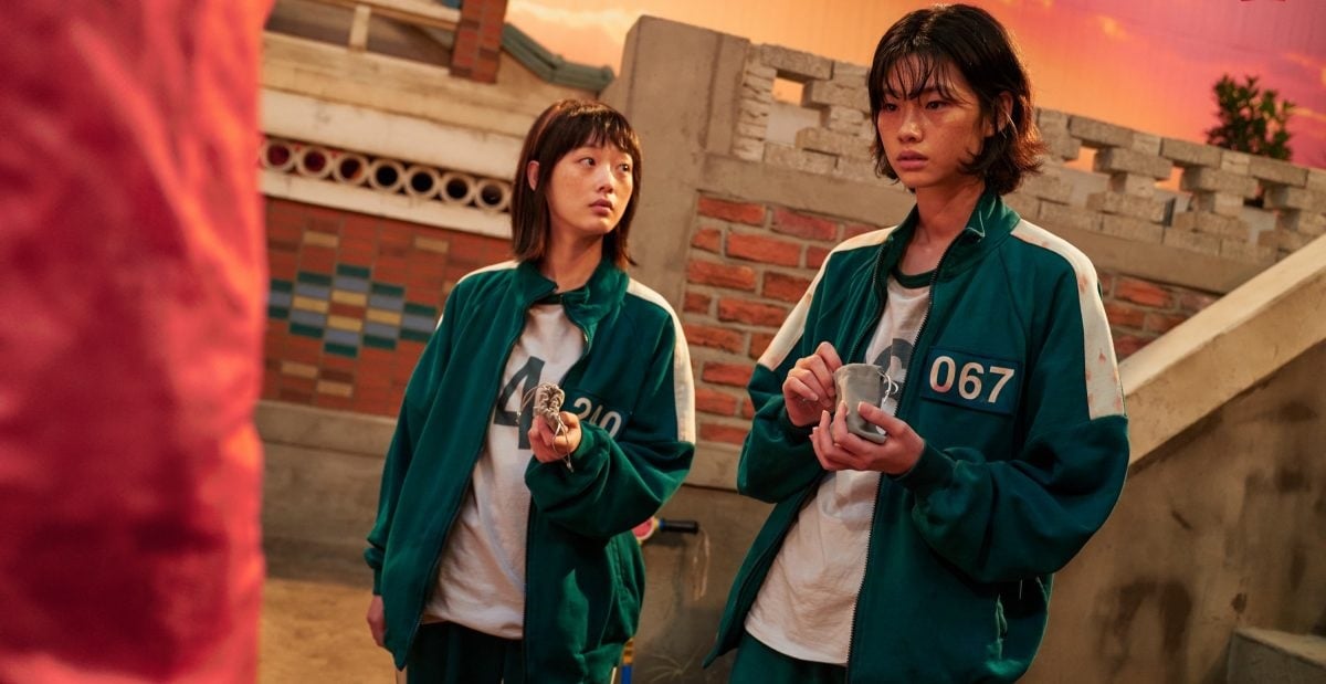 Actors Lee Yoo-Mi as Ji-Yeong and HoYeon Jung as Kang Sae-Byeok for Netflix’s ‘Squid Game’ -- the two wear green track suits with white highlights.