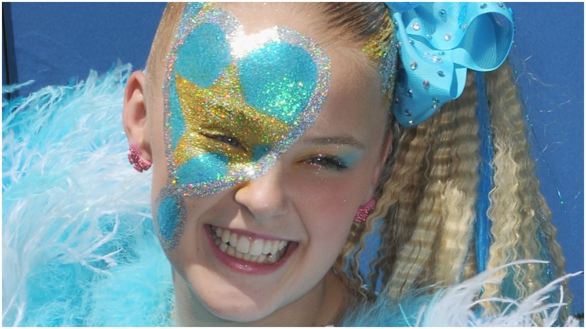 JoJo Siwa wears glittering blue and gold outfit on the red carpet.