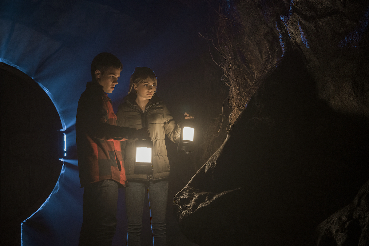 Tyler (Connor Jessup) and Kinsey (Emilia Jones) explore a dark area in a production still from 'Locke & Key' Season 1.