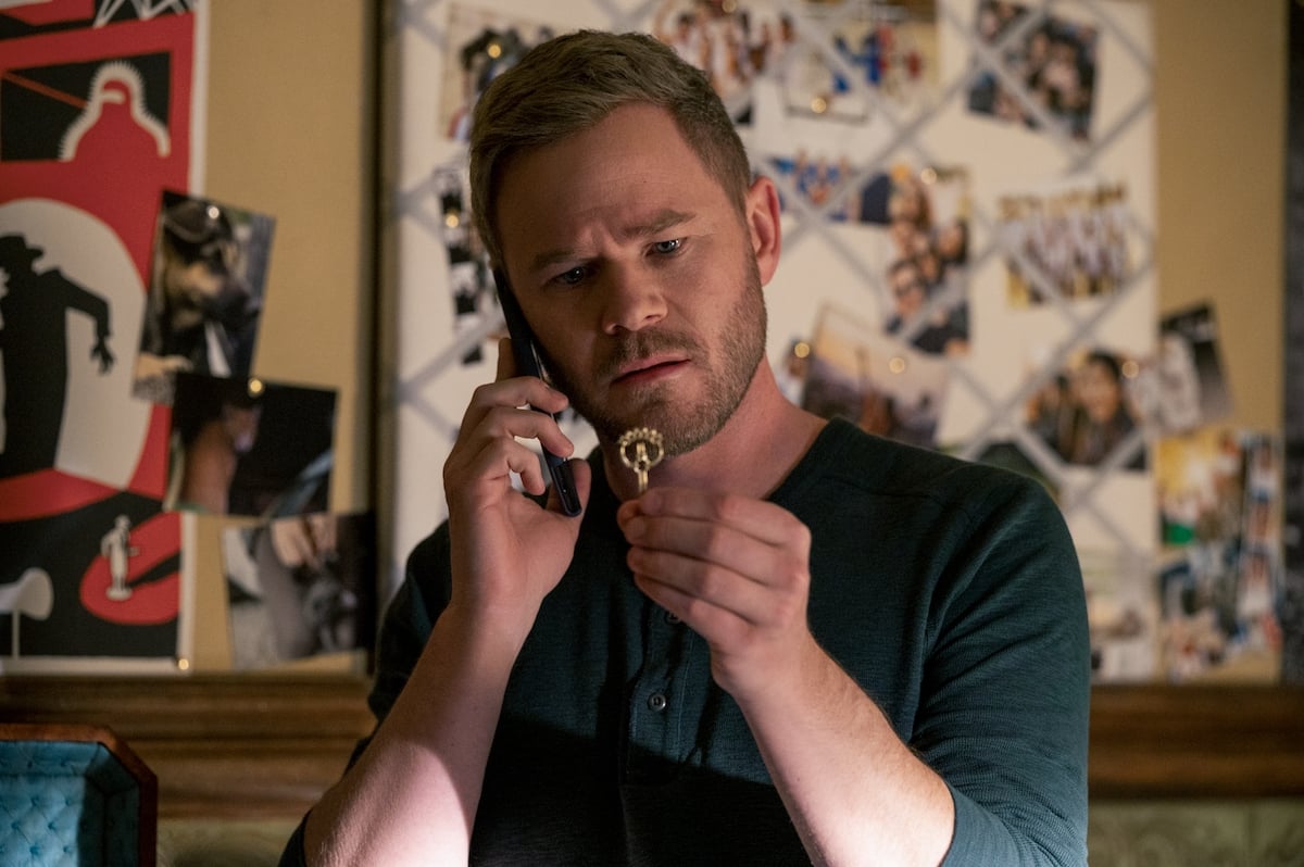 Aaron Ashmore as Duncan Locke staring at a key in a production still from 'Locke & Key' Season 2